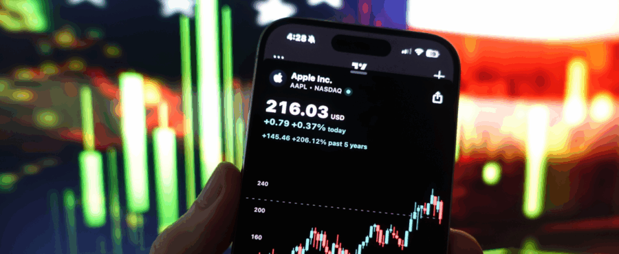 hand holding a phone showing a trading app with Apple stock price